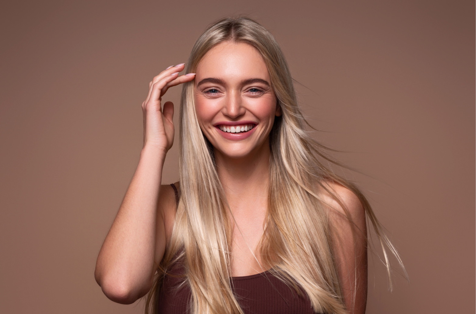 Улыбающаяся женщина с длинными светлыми волосами на нейтральном фоне, принятие себя и уверенность в теле